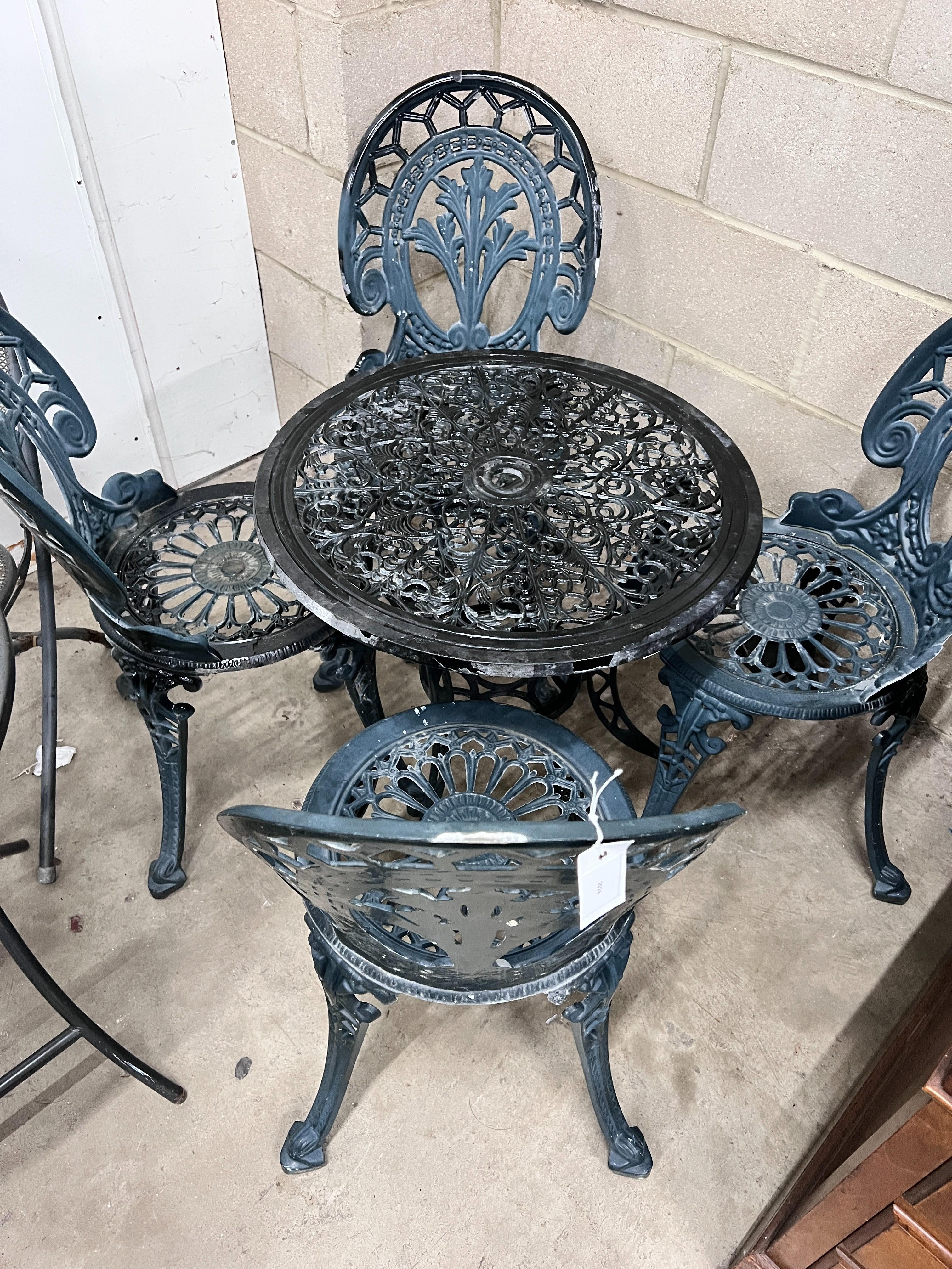 A Victorian style aluminium circular garden table, diameter 60cm, height 62cm and four chairs